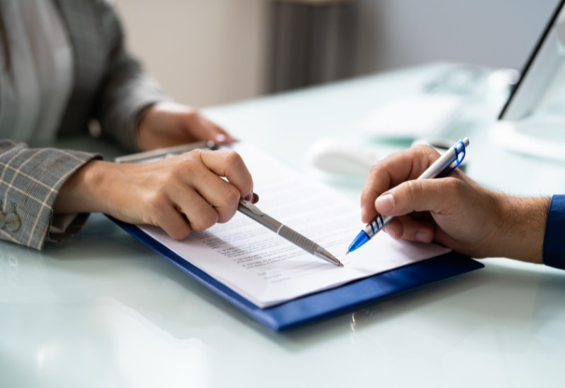 Lawyers mediating and reviewing legal documents, providing legal advice at Wallace Smith Lawyers