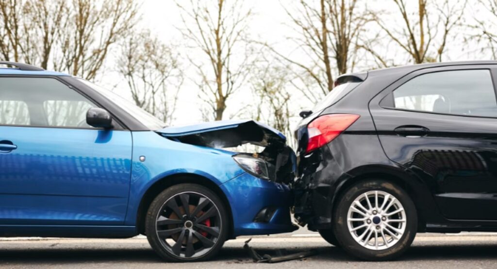 A rear end car crash with visible damage to both cars.